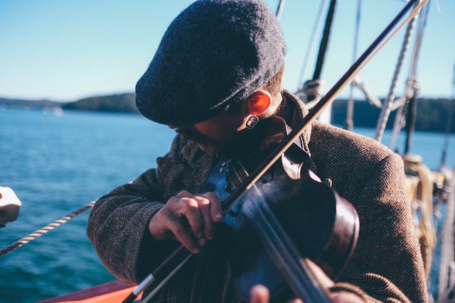 three line tales 234: a man playing the fiddle on a boat